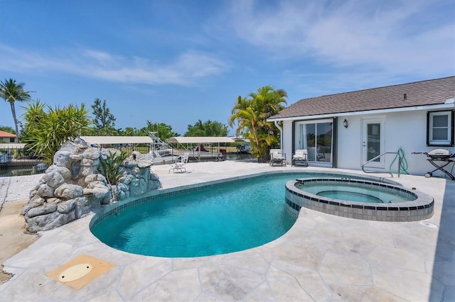 view of swimming pool with a patio area and an in ground hot tub