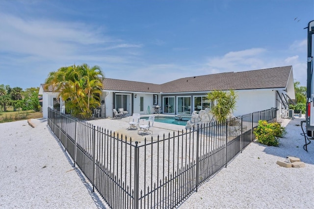 rear view of property featuring a patio area, a fenced in pool, and central air condition unit