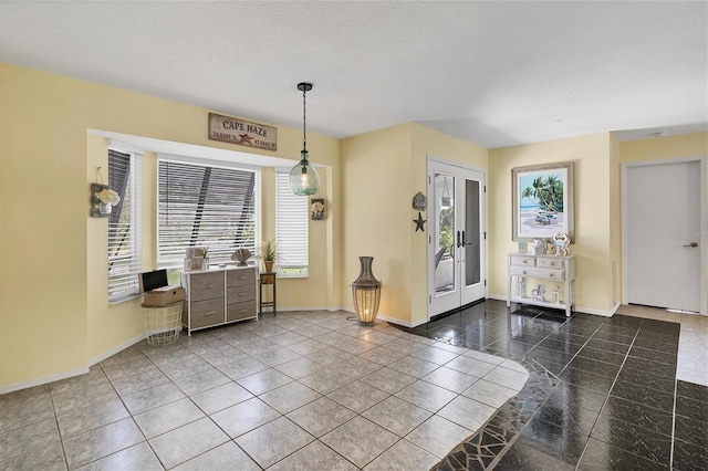 tiled entrance foyer with a healthy amount of sunlight and french doors