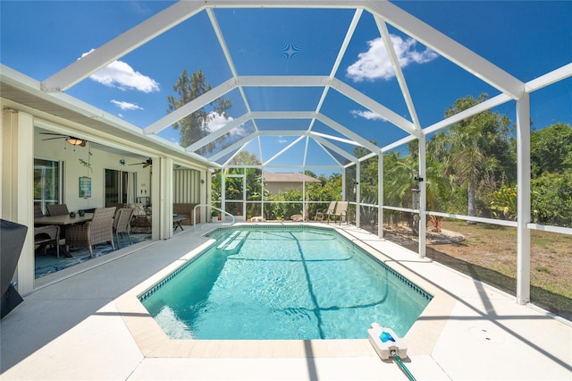 view of pool with ceiling fan, a lanai, and a patio