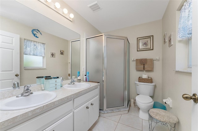 bathroom with vanity with extensive cabinet space, toilet, tile flooring, a shower with door, and double sink