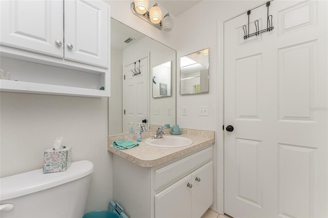 bathroom with vanity with extensive cabinet space and toilet