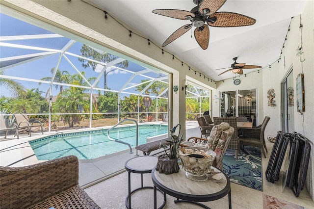 view of swimming pool featuring glass enclosure, a patio area, and ceiling fan