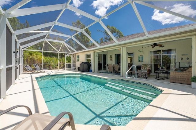 view of pool with a patio, glass enclosure, and ceiling fan