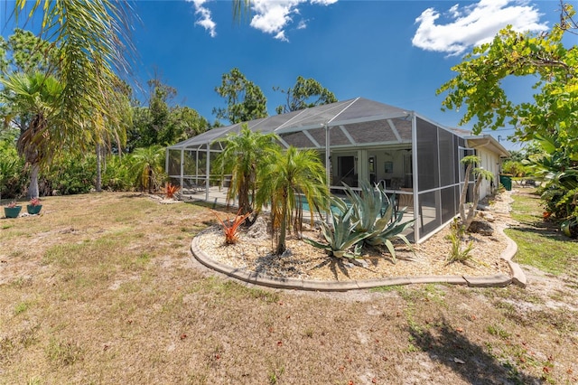 view of yard featuring glass enclosure and a swimming pool