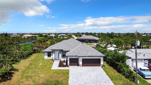 view of front of property featuring a water view, a front yard, and a garage