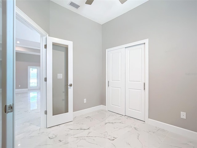 unfurnished bedroom featuring ceiling fan and a closet