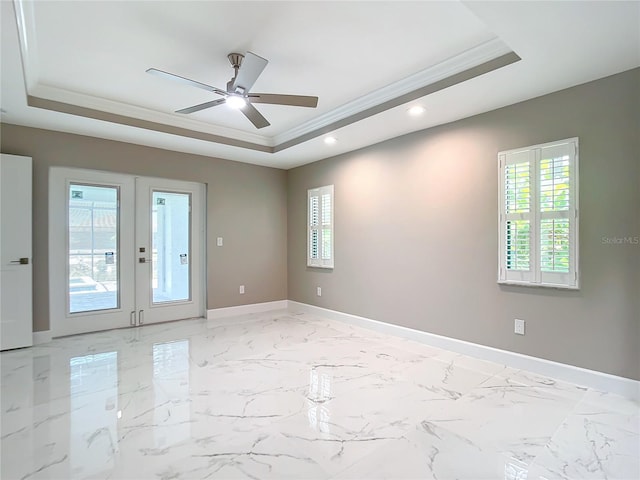 unfurnished room featuring a tray ceiling, crown molding, and french doors