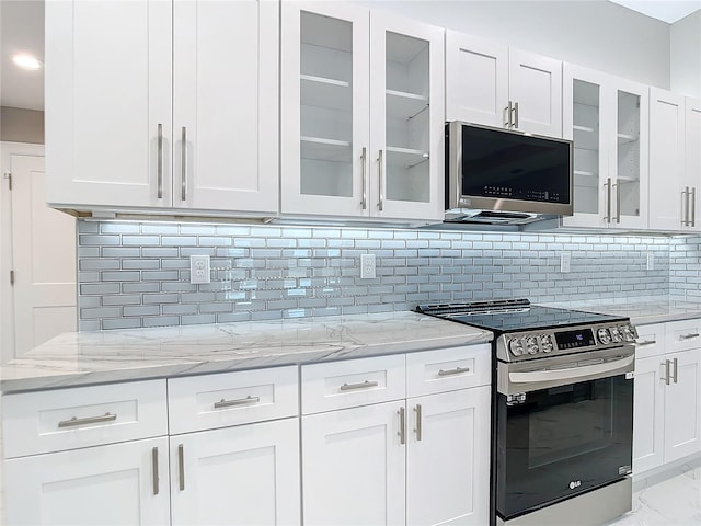 kitchen featuring backsplash, light stone countertops, white cabinets, and appliances with stainless steel finishes