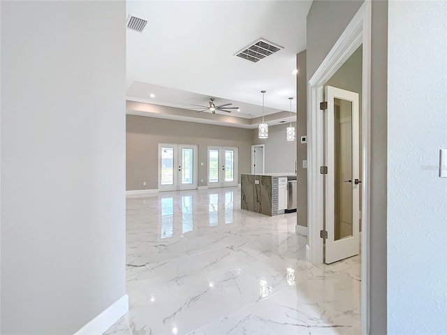 hall with a raised ceiling and french doors