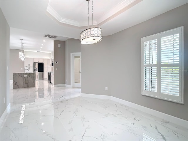 unfurnished room with a raised ceiling, ornamental molding, and sink