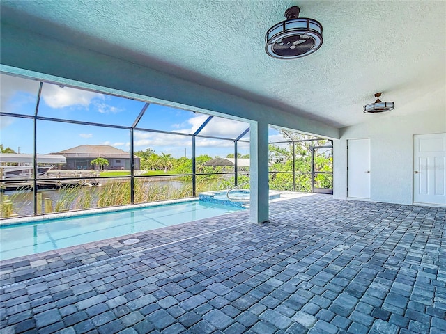 view of pool with a lanai, a patio area, and a water view