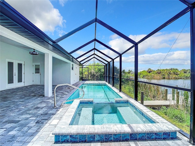 view of swimming pool featuring glass enclosure, french doors, an in ground hot tub, a water view, and a patio