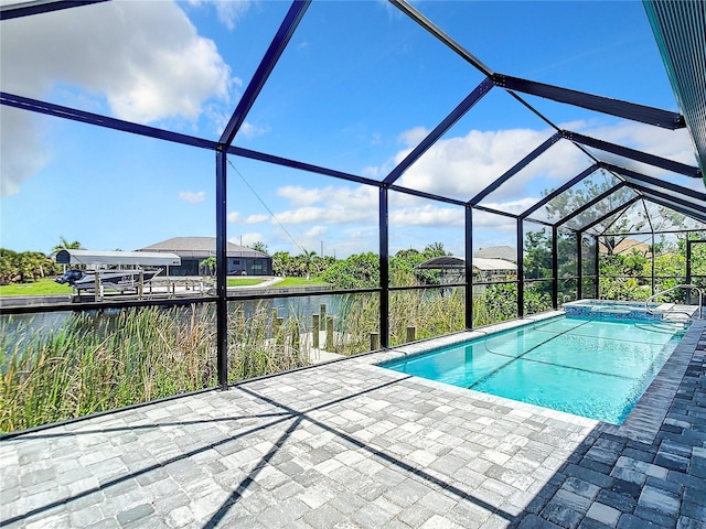 view of pool featuring an in ground hot tub, a patio, a water view, and glass enclosure