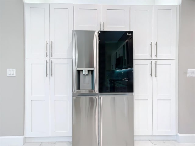 kitchen featuring stainless steel fridge with ice dispenser and white cabinets