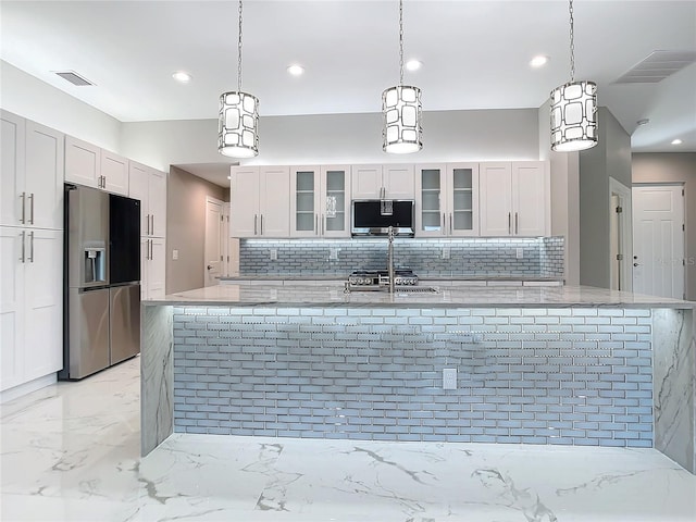 kitchen featuring white cabinets, decorative light fixtures, stainless steel appliances, and decorative backsplash