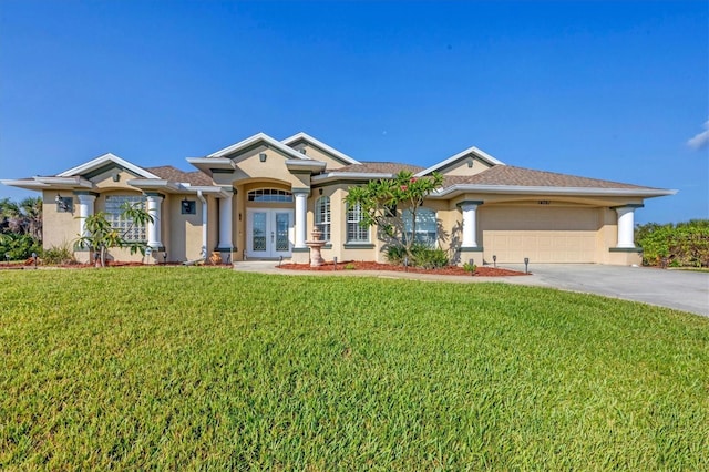 view of front of property with french doors, a garage, and a front lawn