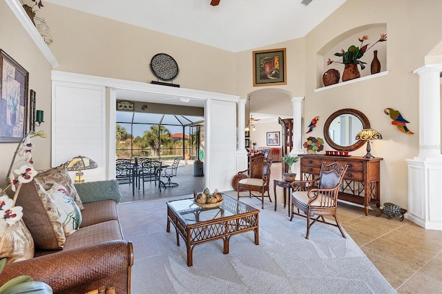 sitting room with light tile patterned floors, decorative columns, vaulted ceiling, and ceiling fan