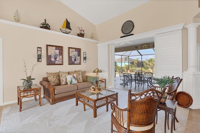 carpeted living room featuring ornate columns and high vaulted ceiling