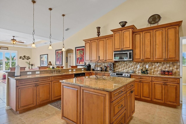 kitchen with kitchen peninsula, a center island, hanging light fixtures, and appliances with stainless steel finishes