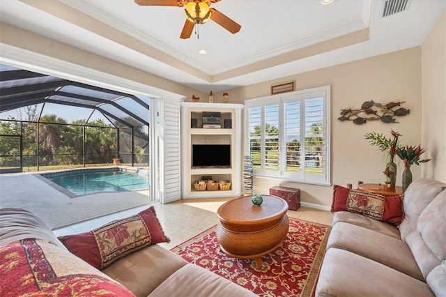 living room featuring ornamental molding, a raised ceiling, vaulted ceiling, ceiling fan, and light tile patterned flooring