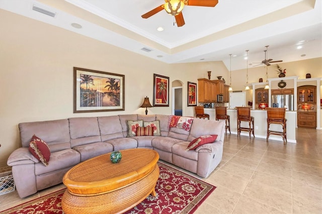 living room with light tile patterned floors, a tray ceiling, and ceiling fan