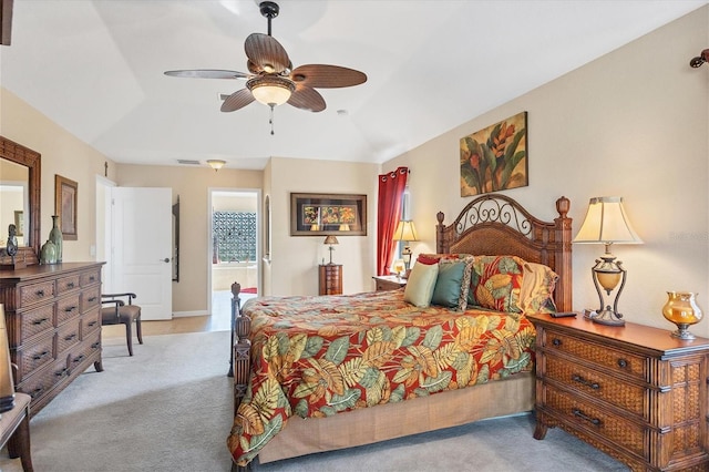 carpeted bedroom with ensuite bath, vaulted ceiling, and ceiling fan