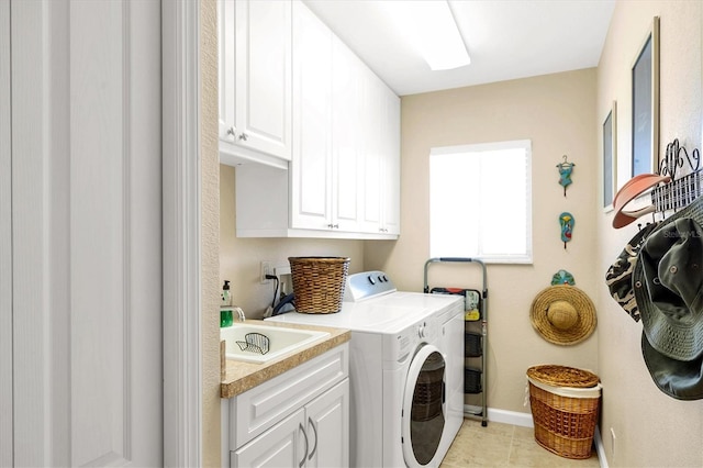 laundry room with washer and clothes dryer, sink, light tile patterned floors, and cabinets