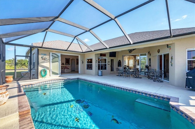 view of swimming pool featuring a patio area, ceiling fan, and a lanai