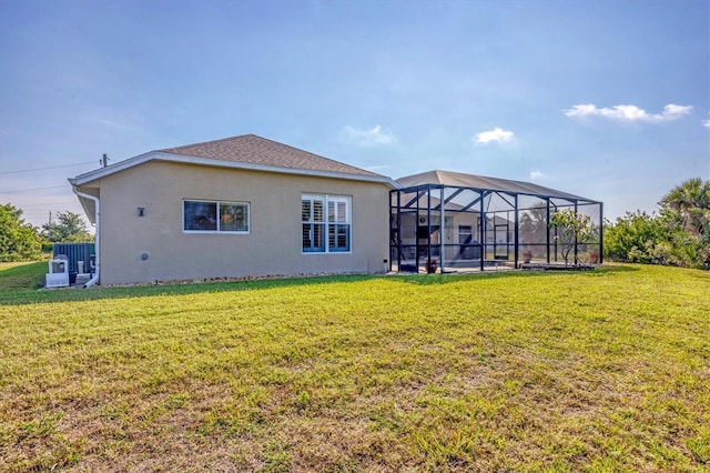 back of house with a yard and a lanai