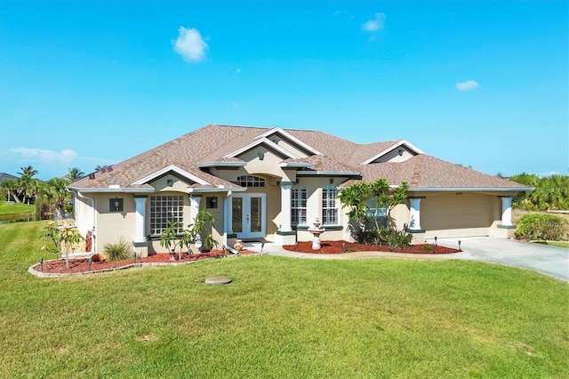 ranch-style home featuring a front yard, french doors, and a garage