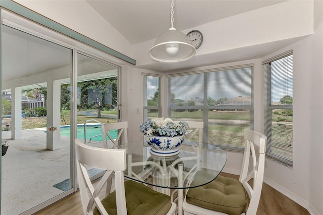 dining space with plenty of natural light, vaulted ceiling, and wood-type flooring