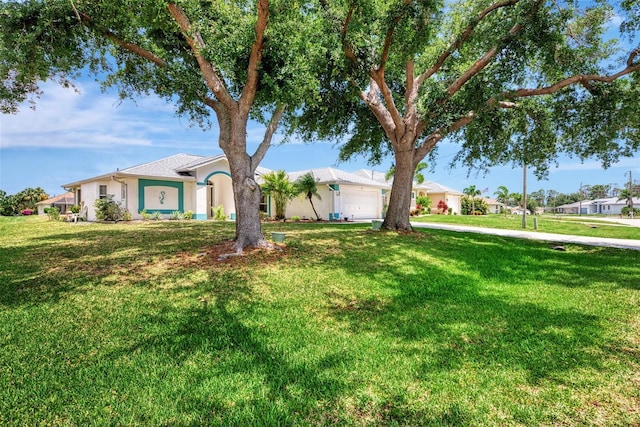 single story home with a garage and a front lawn