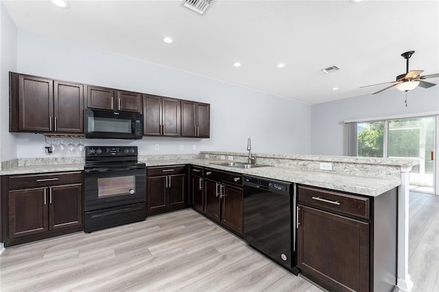 kitchen with black appliances, sink, kitchen peninsula, dark brown cabinets, and light wood-type flooring