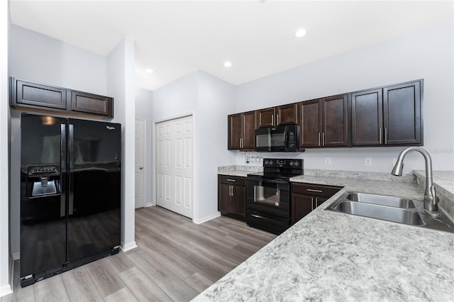 kitchen featuring dark brown cabinetry, sink, light hardwood / wood-style flooring, and black appliances