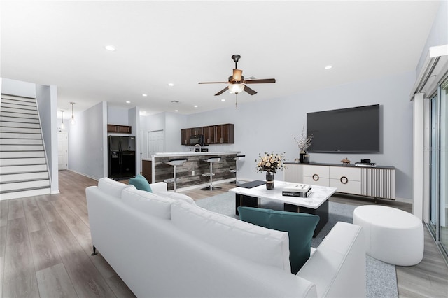 living room featuring light hardwood / wood-style floors and ceiling fan