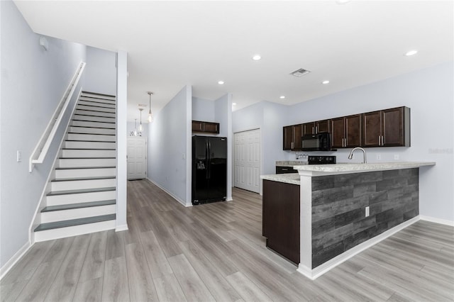 kitchen with dark brown cabinets, kitchen peninsula, light hardwood / wood-style floors, and black appliances