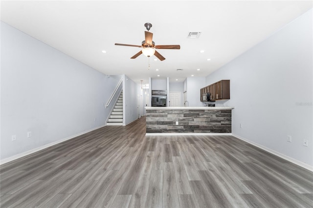 unfurnished living room featuring ceiling fan and hardwood / wood-style floors