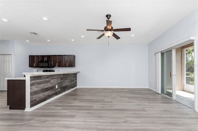 unfurnished living room with ceiling fan, sink, and light hardwood / wood-style flooring