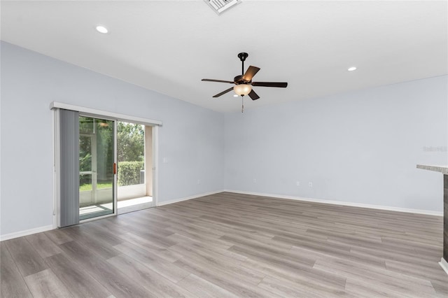 spare room with ceiling fan and light wood-type flooring