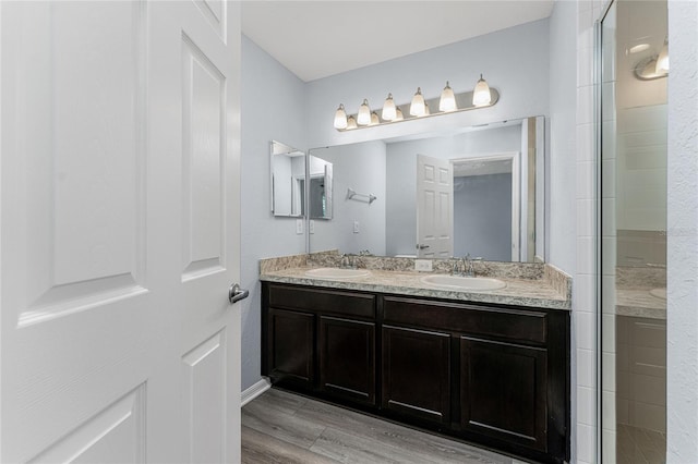 bathroom featuring vanity, wood-type flooring, and a shower with door