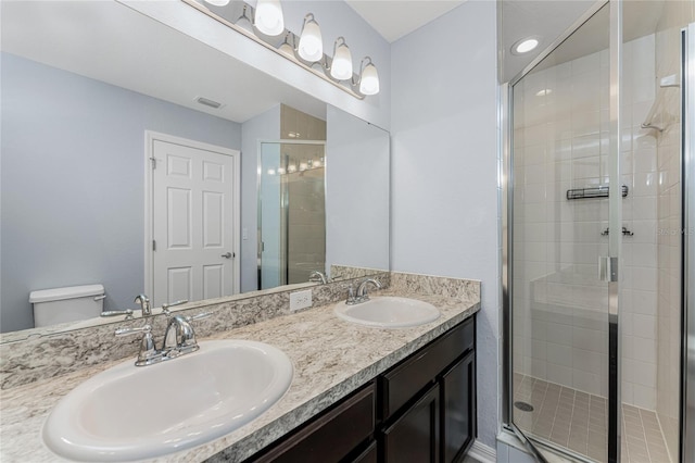 bathroom featuring vanity, toilet, and a shower with shower door