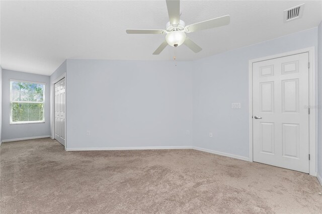 carpeted empty room featuring ceiling fan