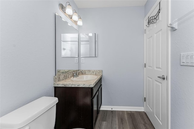 bathroom with vanity, wood-type flooring, and toilet