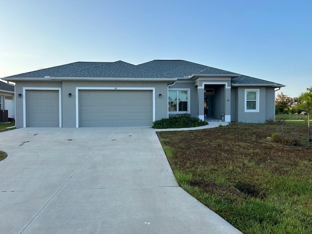 view of front of home with a garage, a front lawn, and central AC unit