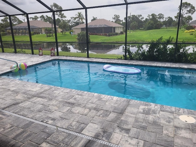 view of swimming pool featuring glass enclosure, a patio area, and a lawn