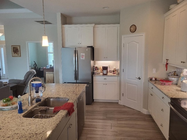 kitchen with appliances with stainless steel finishes, sink, hardwood / wood-style floors, and white cabinetry