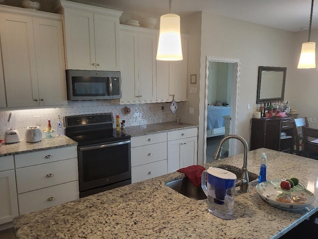 kitchen with white cabinetry, tasteful backsplash, light stone counters, electric stove, and decorative light fixtures