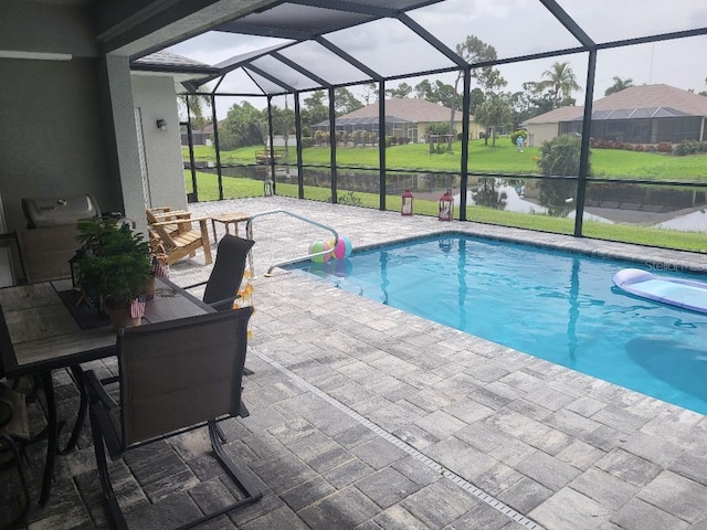 view of swimming pool with glass enclosure, a patio area, and a yard