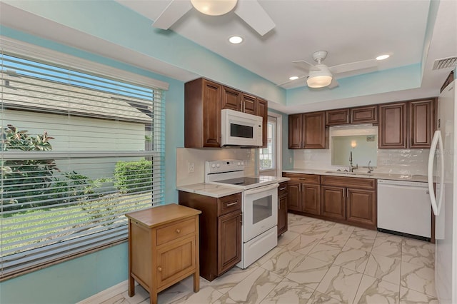 kitchen with white appliances, backsplash, ceiling fan, and sink